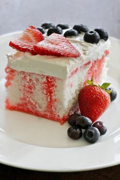 a piece of red, white and blue cake on a plate with berries around it