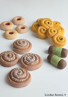 there are many different types of donuts on the white table and one is made out of clay