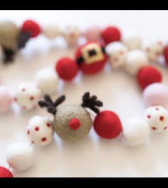 a close up of a beaded necklace with red and white balls on it's sides