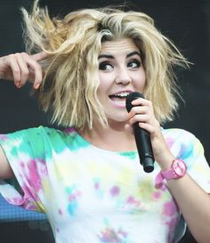 a woman with blonde hair holding a microphone