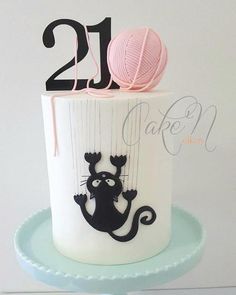 a birthday cake decorated with a cat and ball of yarn