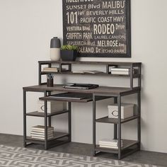 a computer desk sitting on top of a wooden floor next to a black and white wall