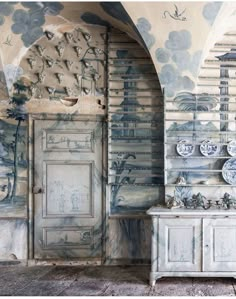 an artisticly decorated room with blue and white wallpaper, painted on the walls