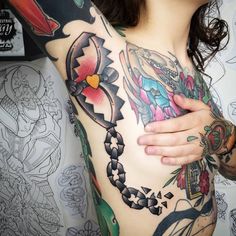 a woman with tattoos on her chest and arm