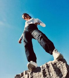 a man riding a skateboard up the side of a rock formation on a sunny day