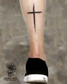 a person with a cross tattoo on their foot