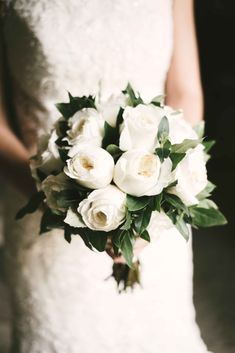 a bride holding a bouquet of white flowers