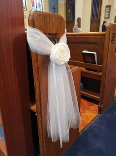 a white flower on the back of a church pew