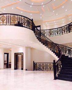 a spiral staircase in the middle of a large room with white walls and flooring