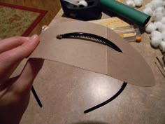 someone is making a paper bag that looks like a man's face with scissors