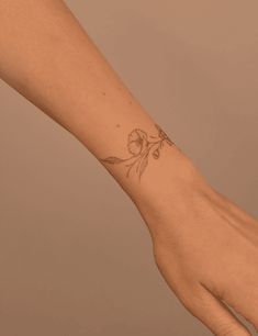 a woman's hand with a flower tattoo on it