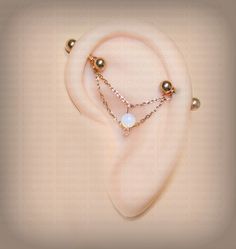 a pair of ear piercings with pearls on them