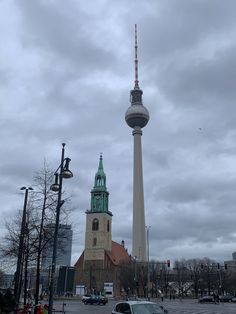 a very tall tower with a clock on it's side in the middle of a city