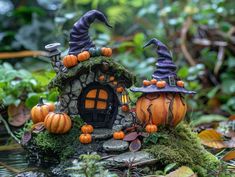 two pumpkins sitting on top of a moss covered rock with a house in the background