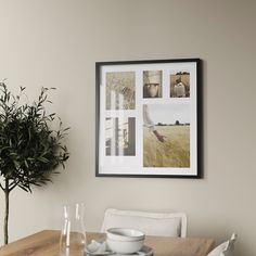 a dining room table with plates and cups on it, in front of a framed photograph