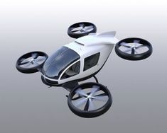 a white and black remote controlled helicopter flying in the air with wheels on each side