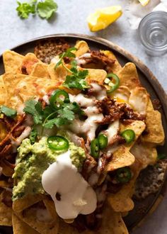 a plate filled with nachos and guacamole on top of it