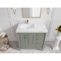 a bathroom vanity with a marble top and gold hardware on the handles is shown in this image