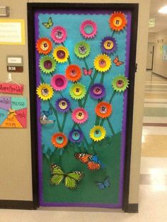 a door decorated with flowers and butterflies in the middle of an empty hallway at school