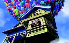 there is a house with many balloons on the roof and in the air above it