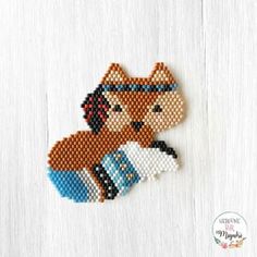 a cross stitch fox with a sock on it's back, sitting on a white surface