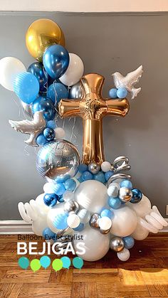 the balloon bouquet is decorated with blue, white and gold balloons that are shaped like an angel