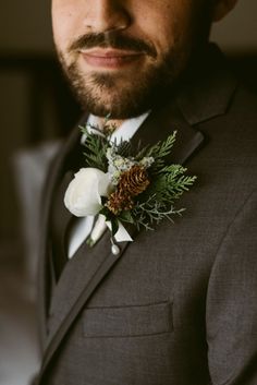 a close up of a person wearing a suit and flowers in his lapel flower