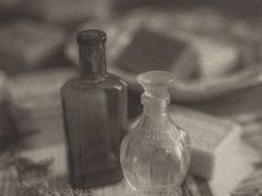 two glass bottles sitting next to each other on a table