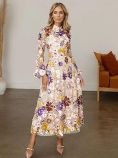 a woman in a floral dress posing for the camera