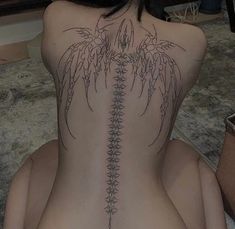 the back of a woman's body with tattoos on it