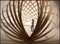 a person standing in front of a wooden sculpture