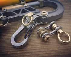 several different types of metal objects on a wooden table next to a pair of scissors