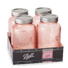 four pink ball mason jars with lids in a black box on a white background,