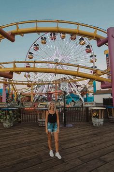 a woman standing in front of a carnival ride