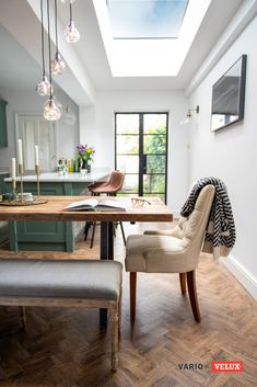 a dining room table with chairs and a skylight above it that reads extending or renovating?