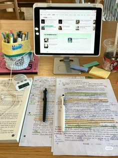 an open book sitting on top of a wooden desk next to a computer monitor and keyboard