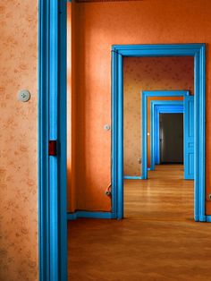 an empty room with blue doors and orange walls