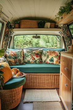 the inside of a camper with lots of plants and pillows on it's windowsill