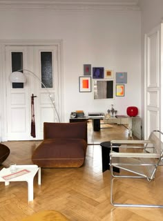 a living room filled with furniture and pictures on the wall