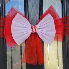 a red and white bow is hanging on the front glass door to show it's colors