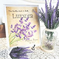 lavender flowers in a vase next to a sign on a lace doily tablecloth