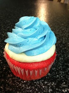 a red, white and blue cupcake sitting on top of a counter