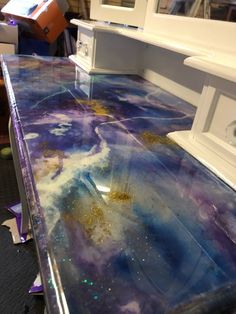 the counter top is covered in purple and blue paint with gold flecks on it