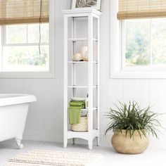 a white bathroom with a tub, toilet and shelf