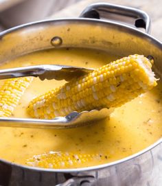 a metal pot filled with corn on the cob