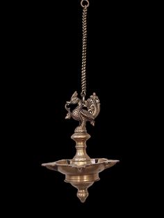 an ornate brass chandelier hanging from a chain on a black background with clippings