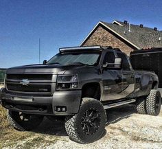 a black truck parked in front of a house