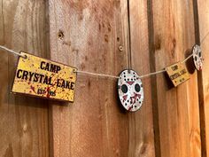 there is a sign that says camp crystal - lake and two masks hanging on a rope