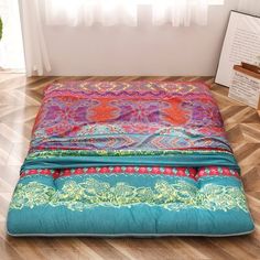 the floor mat is covered in colorful fabric and has an intricate design on it, along with a potted plant