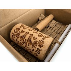 a wooden baseball bat in a box with decorative designs on the top and bottom part